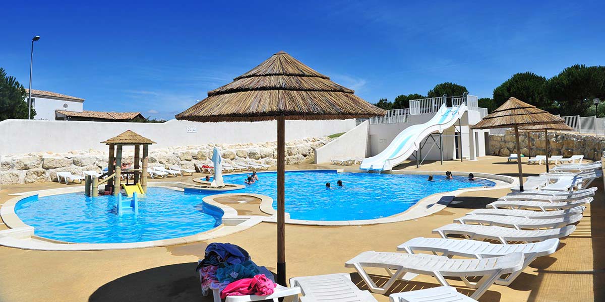 Deckchairs and parasol at the edge of the aquatic area in Arvert