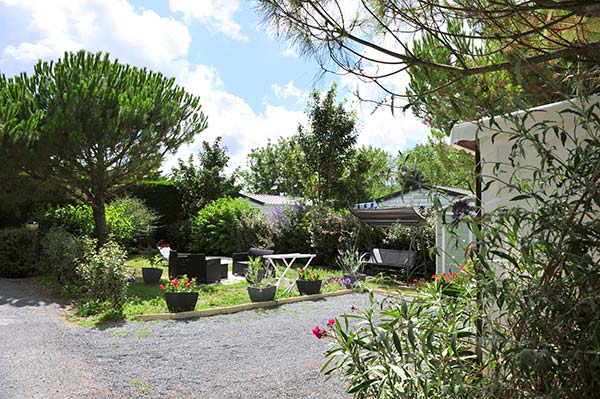 Parcelle avec mobil-home entourée de verdure au camping Parc de Bellevue en Charente-Maritime