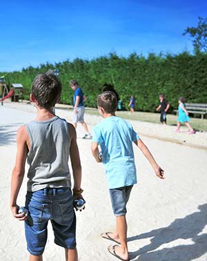 Children playing pétanque on the boules court at the Parc de Bellevue campsite in Arvert