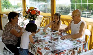 Grandparents and children on the terrace of a mobile home at the Parc de Bellevue campsite