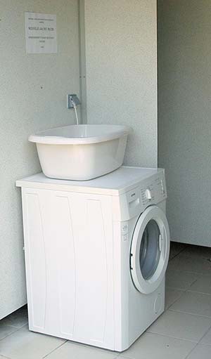 Laundry area with washing machine at the Parc de Bellevue campsite in Arvert