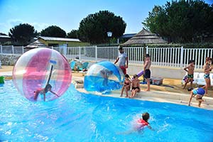 Inflatable waterballs and miniboats games in the campsite pool