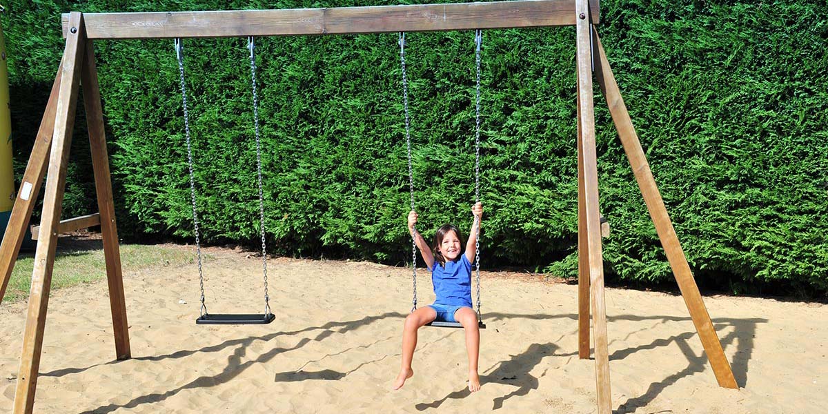 Swings on the playground of the Parc de Bellevue 17 campsite