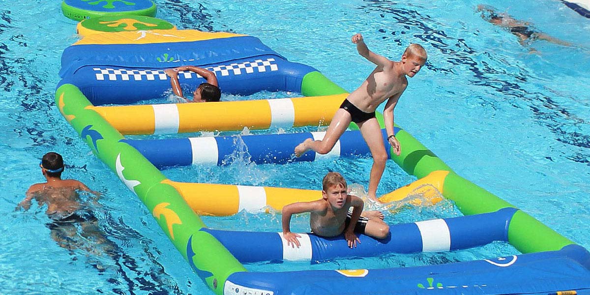 Children playing on an Aqua Track in the swimming pool of the campsite in Arvert