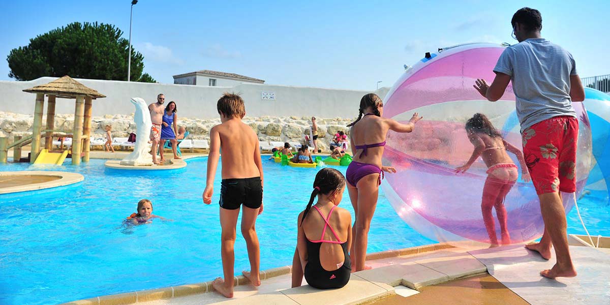 Children playing waterball in the swimming pool of the campsite in Arvert