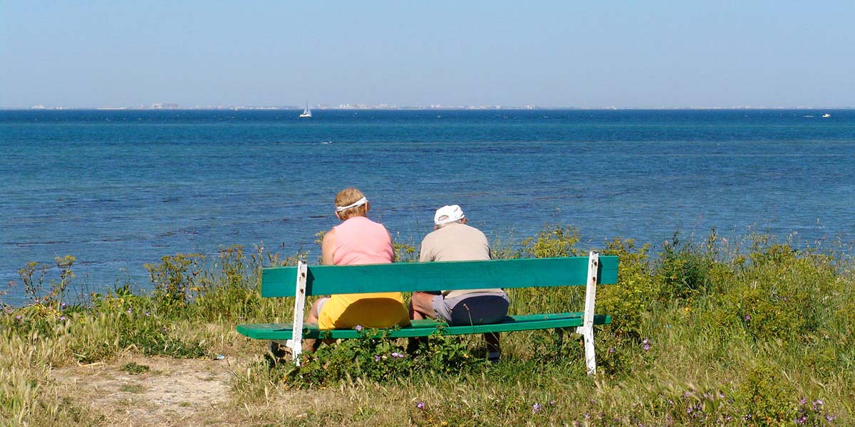 Retired couple on a bench by the sea in Arvert