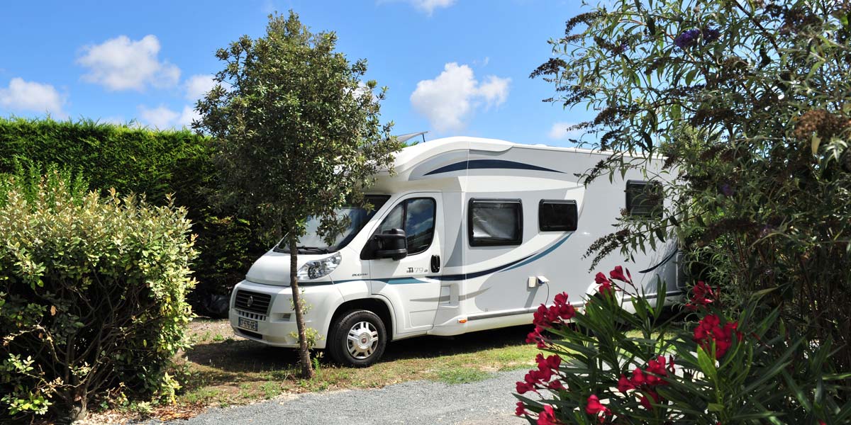 Motorhome parked under the trees at the Parc de Bellevue campsite in Arvert
