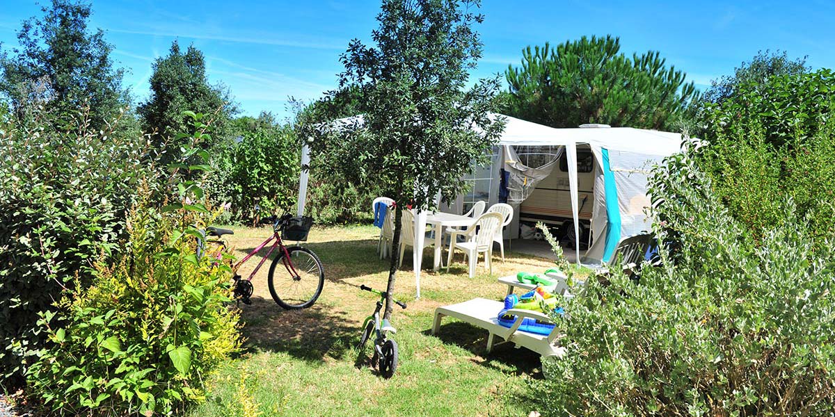 Emplacement de camping dans la verdure du camping Parc de Bellevue près de la Palmyre